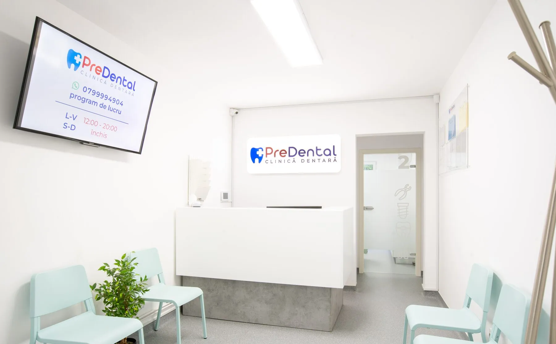 Recepția clinicii PreDental, cu birou alb și logo pe perete